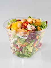 Salad in takeaway container on white background