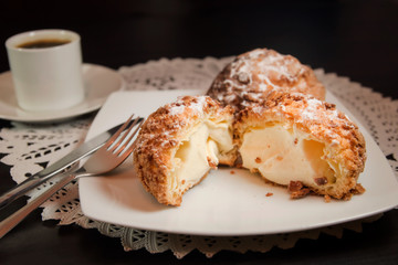 Choux cream or cream puff and coffee on dark background. Selective focus.