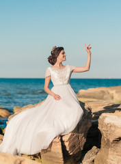 Fototapeta na wymiar Romantic beautiful bride in luxury dress posing on the beach.