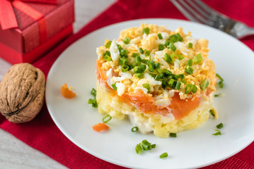 Szuba - herring under the coat -  traditional multilayered polish salad from herring, potatoes, carrots and eggs decorated with chives.