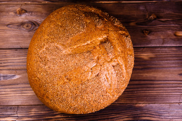 Loaf of bread on wooden table. Top view