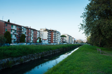 Fototapeta na wymiar Canale, corso d' acqua, fiume con palazzi residenziali al crepuscolo