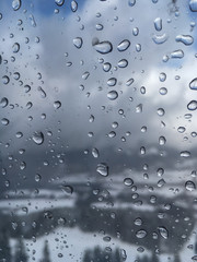 Waterdrops in a cable car gondola with a winter landscape in the background