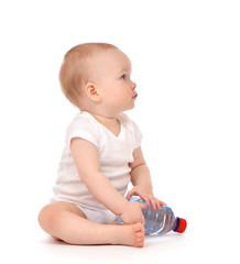 Infant child baby sitting with bottle of drinking water in diaper