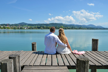 A couple on the wooden jetty at the lake. Switzerland
