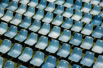 Rows of numbered plastic chairs prepared for an event outdoors