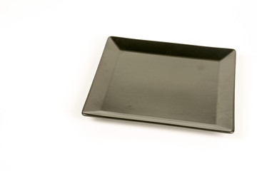 Modern square black plate isolated above white background
