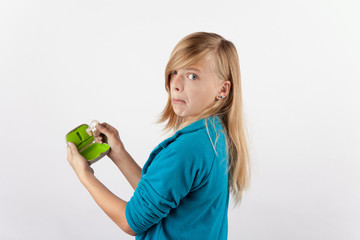 Girl holding a hearing aid and its box expressing negativity
