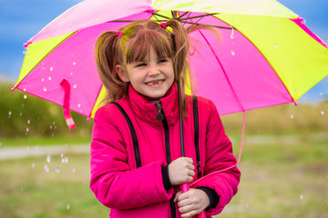 Girl with an umbrella are enjoying rainfall in autumn day
