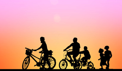 Obraz premium Silhouette family and bike relaxing on sunrise