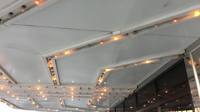 Lights flickering in slow motion under marquee at downtown theater. 