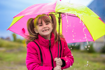 Girl with an umbrella are enjoying rainfall in autumn day