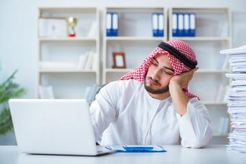 Arab businessman working in the office doing paperwork with a pi