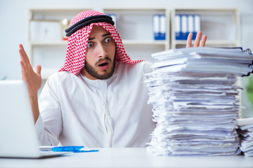 Arab businessman working in the office doing paperwork with a pi