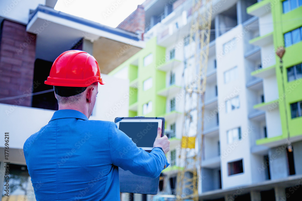 Wall mural construction worker checking location site with crane