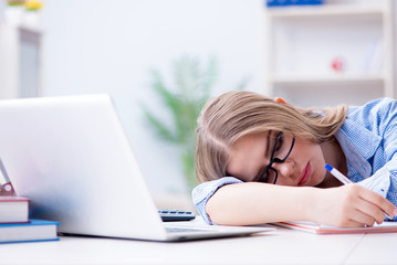 Young teenage female student preparing for exams at home