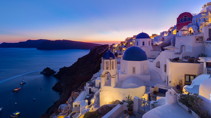 Cityscape of Oia, traditional greek village with blue domes of churches, Santorini island, Greece...