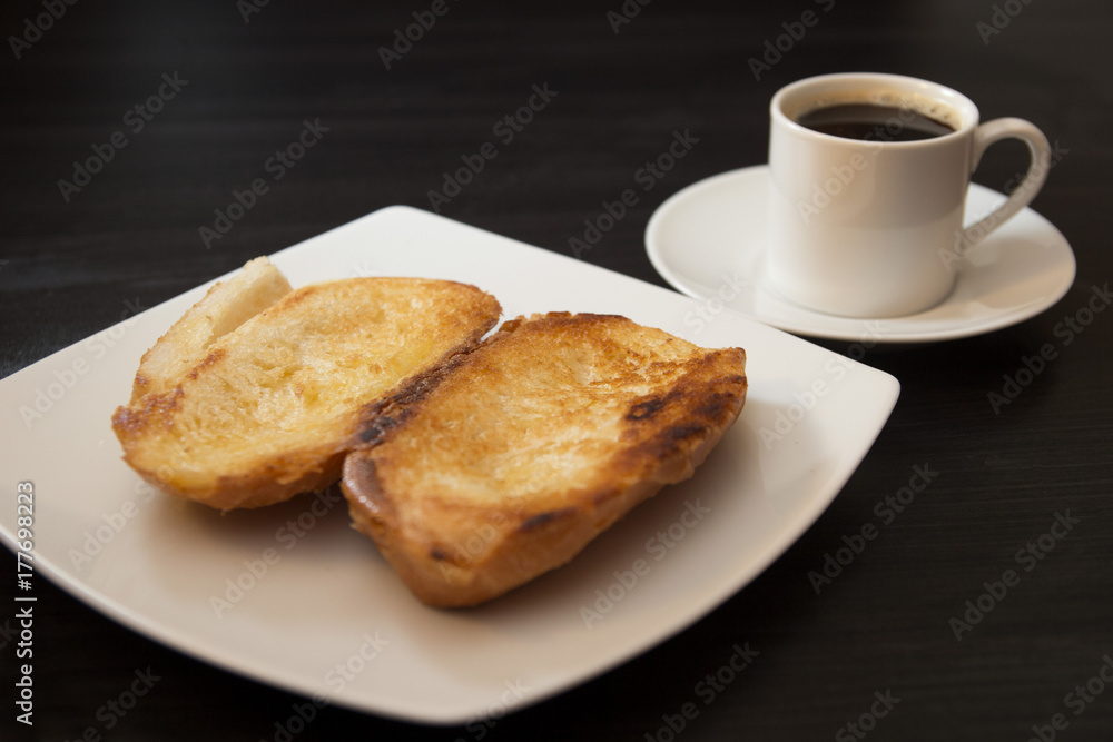 Wall mural French bread toasted with butter on the plate with coffee. Pao na chapa traditional brazilian breakfast. Overview