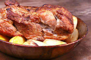 Juicy pork neck chops are grilled with potatoes on a stone Background.