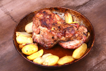 Juicy pork neck chops are grilled with potatoes on a stone Background.
