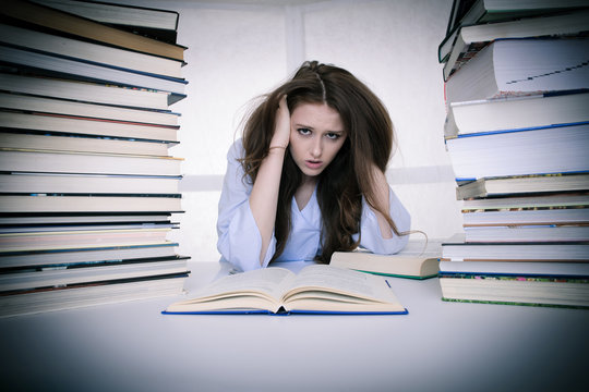 attractive young woman student undre stress while studiing for exames