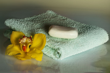 Yellow orchid with white soap and towel on the white background - wellness & spa