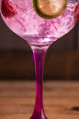 Pink tonic gin with raspberries, wooden background