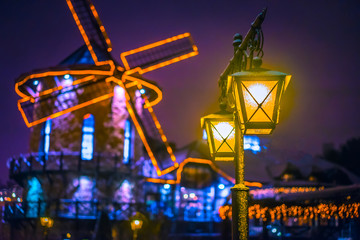 Evening light from the ancient lanterns. Mill with illumination.