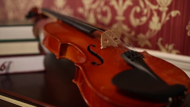 kırmızı duvarın &ouml;n&uuml;nde duran keman... klasik m&uuml;zik, nota, enstr&uuml;man