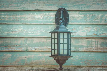 Close up old vintage wall lamp on wooden wall in vintage style.