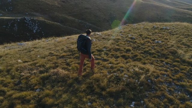 tourist with a backpack walks among the hills