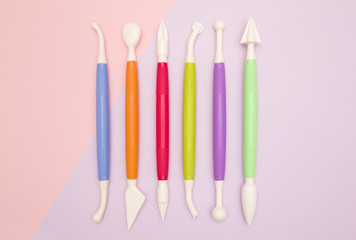 Six Fondant Decorating Instruments on a Pink and Purple Background