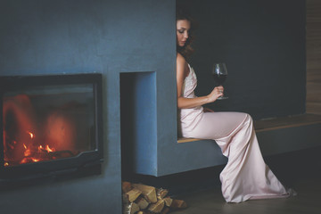 Sexy woman in front of the fireplace. Wood fireplace.