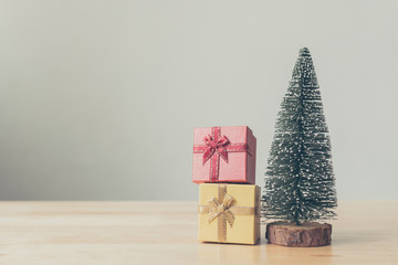 Christmas tree and gift box red, yellow color on wood table with white wall background, Christmas holiday celebration and boxing day concept, Copy space