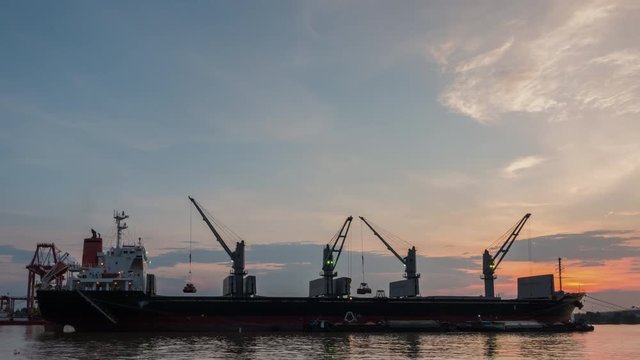 4K Time Lapse : Cargo ship are loading sugar into the bilge with sunset.