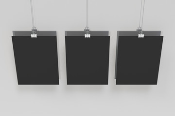 Three blank black posters with binder clip mockup on white background