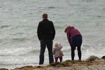 family life by the sea with father, daughter and mother 