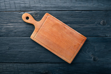 Kitchen wooden board. On a wooden background. Top view. Free space for your text.