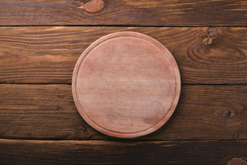 Kitchen wooden board. On a wooden background. Top view. Free space for your text.