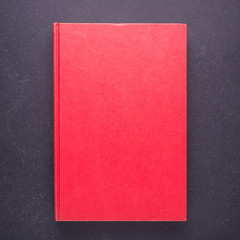 Red book with blank empty cover on black stone table background