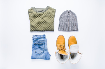 Hiking boots and teen clothing on white background. Flat lay and top view