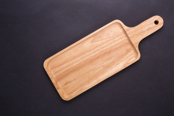 Bright empty wooden dish/bowl on black stone board background