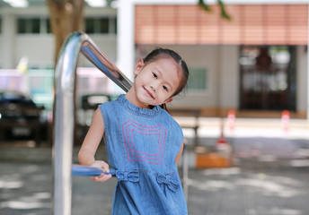 Portrait of little asian girl posing with metal stair.