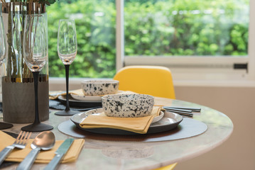 table set on round table with yellow chair