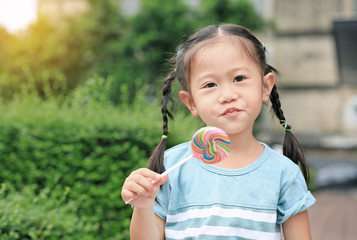 Cute happy asian little girl with lollipop candy.