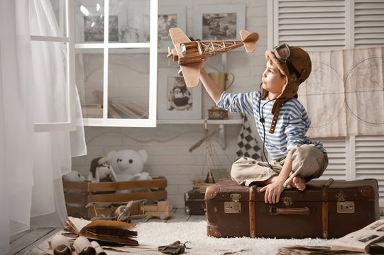 Boy in his room playing with plane