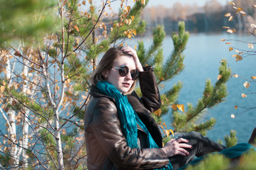 Fototapeta na wymiar girl on a background of nature water and yellow leaves in autumn