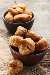 Dried figs in bowls on grey wooden table