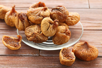 Dried figs in glass plate on brown wooden table