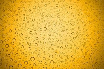 Water drops on yellow glass, Rain droplets on glass background.